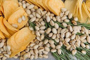 Beer snacks on craft paper. Assorted nuts and chips. Top view with copyspace black background photo