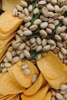 Beer snacks on craft paper. Assorted nuts and chips. Top view with copyspace black background photo