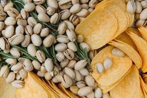 Beer snacks on craft paper. Assorted nuts and chips. Top view with copyspace black background photo