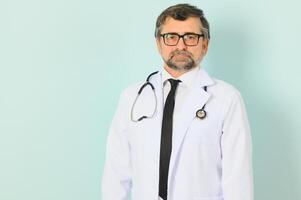 Professional Doctor Man In White Uniform Posing on Blue Studio Background. Panorama With Copy Space. photo
