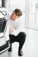 Happy man showing the key of his new car. photo