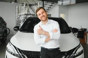 Man adult customer male buyer client chooses auto wants to buy new automobile touch check car in showroom vehicle salon dealership store motor show indoor. Sales concept photo