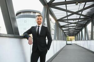 Stockbroker near the office. A successful and advanced handsome business man in a suit looks up in front of him standing on the background of concrete steps. photo