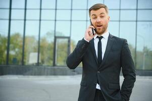 Businessman using smartphone in covered walkway. photo