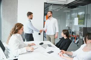 Smiling male business partners negotiators handshake start group office negotiation, company representatives welcoming shake hands at meeting getting acquainted expressing respect make financial deal photo