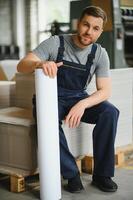Portrait of production line worker controlling manufacturing process of modern packaging industrial machine in printing factory photo