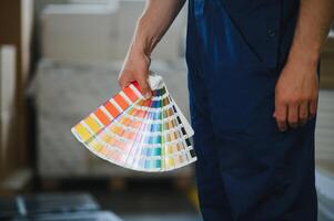 Man working in printing house with paper and paints photo