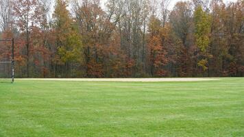 The wide playground view surrounded by the colorful forest woods in autumn photo