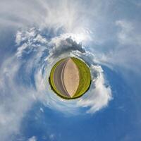 simple little tiny planet without buildings in blue sky with beautiful clouds. Transformation of spherical panorama 360 degrees. Spherical abstract aerial view. Curvature of space. photo
