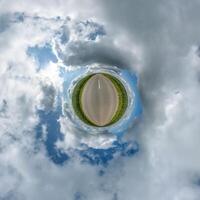 simple little tiny planet without buildings in blue sky with beautiful clouds. Transformation of spherical panorama 360 degrees. Spherical abstract aerial view. Curvature of space. photo