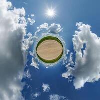 simple little tiny planet without buildings in blue sky with beautiful clouds. Transformation of spherical panorama 360 degrees. Spherical abstract aerial view. Curvature of space. photo