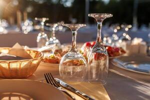 empty wine glasses on banquet served table in open air in rays of setting sun photo
