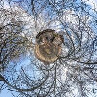 tiny planet transformation of spherical panorama 360 degrees. Spherical abstract aerial view with trees in forest with clumsy branches in blue sky. Curvature of space. photo