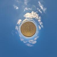 simple little tiny planet without buildings in blue sky with beautiful clouds. Transformation of spherical panorama 360 degrees. Spherical abstract aerial view. Curvature of space. photo