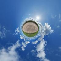 simple little tiny planet without buildings in blue sky with beautiful clouds. Transformation of spherical panorama 360 degrees. Spherical abstract aerial view. Curvature of space. photo