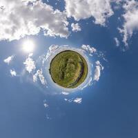 simple little tiny planet without buildings in blue sky with beautiful clouds. Transformation of spherical panorama 360 degrees. Spherical abstract aerial view. Curvature of space. photo