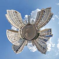 abstract swirling tiny planet spherical panorama of multi-storey buildings of skyscrapers of a residential complex in the form of a butterfly, bugs, crabs in sky with clouds photo