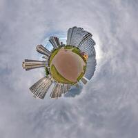 abstract swirling tiny planet spherical panorama of multi-storey buildings of skyscrapers of a residential complex in the form of a butterfly, bugs, crabs in sky with clouds photo