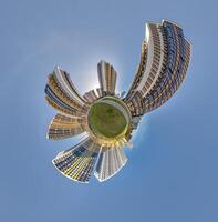 abstract swirling tiny planet spherical panorama of multi-storey buildings of skyscrapers of a residential complex in the form of a butterfly, bugs, crabs in sky with clouds photo