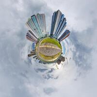 abstract swirling tiny planet spherical panorama of multi-storey buildings of skyscrapers of a residential complex in the form of a butterfly, bugs, crabs in sky with clouds photo