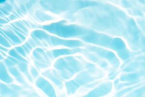 Blue water with ripples on the surface. Defocus blurred transparent blue colored clear calm water surface texture with splashes and bubbles. Water waves with shining pattern texture background. photo