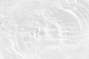 Blue water with ripples on the surface. Defocus blurred transparent blue colored clear calm water surface texture with splashes and bubbles. Water waves with shining pattern texture background. photo