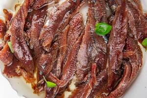 anchovies in a plate on the table canned fish in oil fresh and tasty seafood meal food snack on the table copy space food background rustic photo