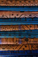 Close up of stacked colorful traditional fabric with intricate patterns, including geometric shapes and star motifs, in Turkey. photo