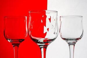 Three empty wine glasses with a red and white striped background. photo