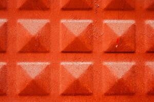 Close up of a terracotta textured surface with a geometric pattern of raised squares, texture, background. photo