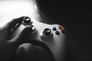 hands with a gamepad against black and white background. low key photo