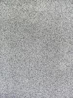 close-up texture shot of a rough, grey surface reminiscent of concrete or stucco. The granular quality and uneven shade variation make it suitable for backgrounds, graphic design photo