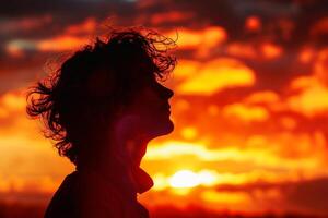 A person in profile standing against a vibrant sunset backdrop creating a golden silhouette. AI generate photo