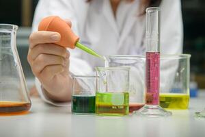 girl scientist loads liquid sample into with plastic pipette. education and science photo