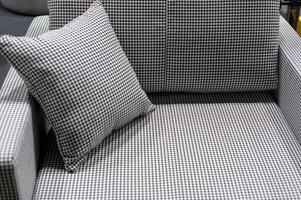 small sofa with a stylish pillow, variegated fabric in black and white tones photo