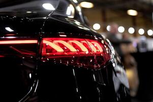 Closeup of a modern car s LED red taillight signaling turning on street to maintain distance with a closeup of the trunk photo