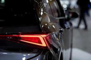 Closeup of a modern car s LED red taillight signaling turning on street to maintain distance with a closeup of the trunk photo