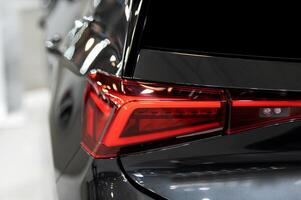 Closeup of a modern car s LED red taillight signaling turning on street to maintain distance with a closeup of the trunk photo