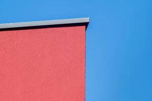 orange painted house wall in front of a blue sky photo