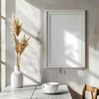 Minimalist interior with a blank picture frame, rustic table, and vase with dried pampas grass by the window. photo