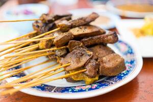 Liver satay or liver pork in bamboo skewers eaten with peanut sauce or sweet and sour sauce. photo
