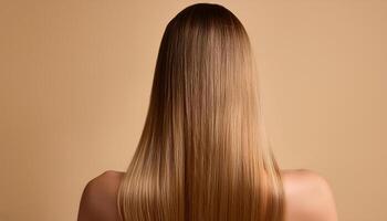 Young woman applying hair mask on beige background, back view photo
