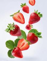 Flying juicy ripe strawberries with leaves isolated on a white background photo