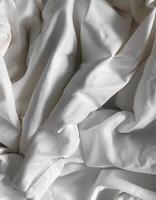 Background concept. Soft bed sheets that are still wrinkled after being used. The white bed sheets were crumpled and shabby. Pattern texture background. photo