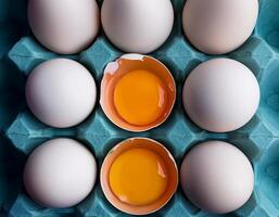photo pallet with eggs and raw broken egg with yolk. Pattern texture background