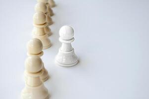 White shining pawn stepping out from the rest of the soldier pawn. Leadership concept. photo