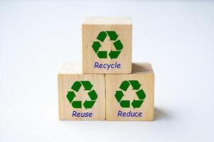 Recycle symbol on wooden cubes with text recycle, reuse and reduce with white cover background photo
