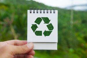 Recycle symbol on white notepad with nature beauty background. Reuse, reduce and recycle photo