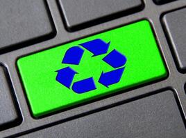 Recycle symbol on green keyboard button. Reuse, reduce and recycle photo