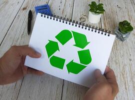 Recycle symbol on white notebook. Reuse, reduce and recycle. photo